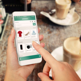 Online shopping on mobile at cafe with coffees